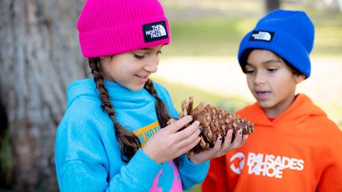 Two kids wear new Palisades Tahoe sweatshirts and hats from The North Face.