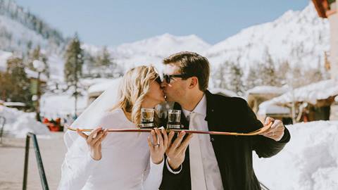 Bride and Groom kiss before a shot ski on the Rocker deck at the Village at Squaw Valley