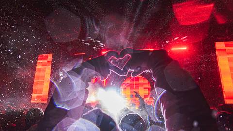 View from the crowd of a festival with heart hands in the air