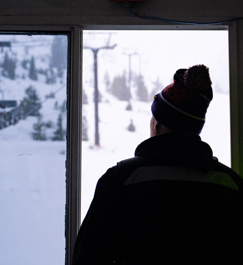 John Haines looking out the window on a snowy morning