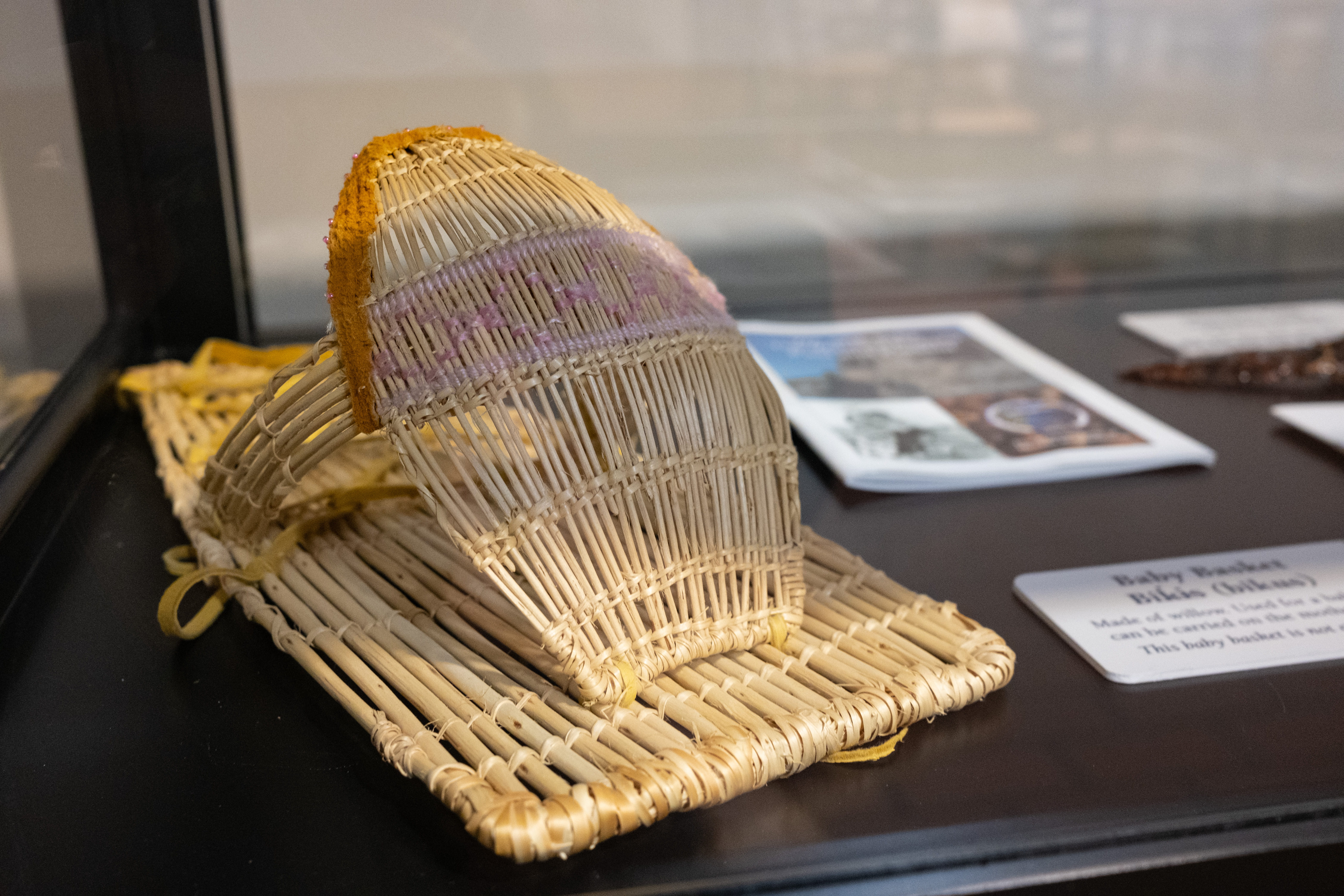 A model of a Washoe baby basket within a display case. 