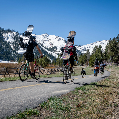 Two snowboarders biking to the mountain on the Olympic Valley trail