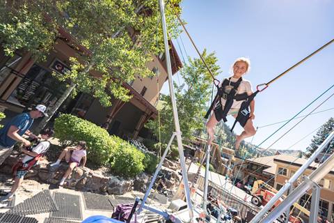 Girl smiling and bouncing on the bungee trampoline at Palisades Tahoe
