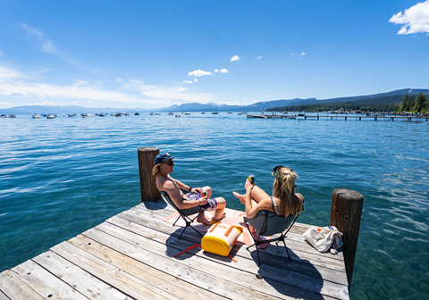 Maddy Condon and Connery Lundin sitting on a dock at Lake Tahoe