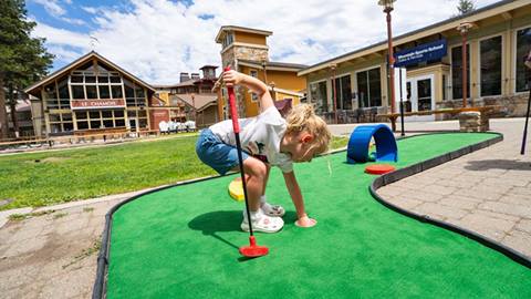 A child plays a round of outdoor mini golf at the resort course in north lake tahoe.