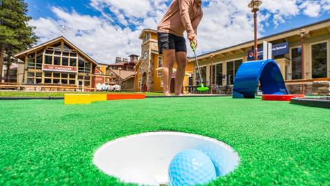 A person putts on the outdoor course at village palisades tahoe mini golf