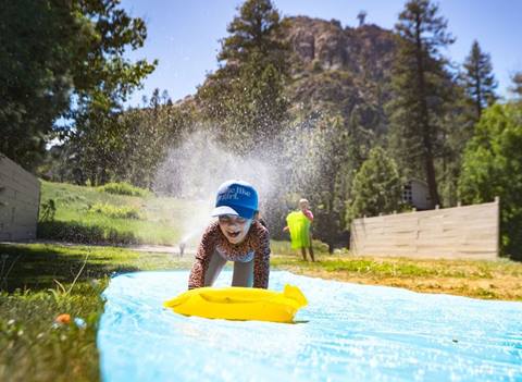 Girl smiling and leaning forward on slide and slide