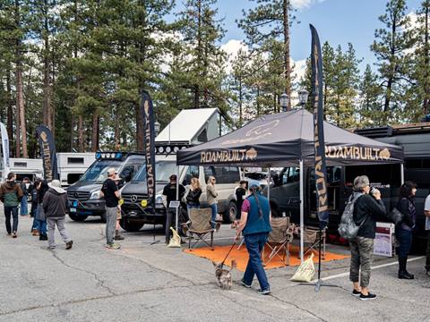 Adventure Van Expo van's displayed in parking lot.