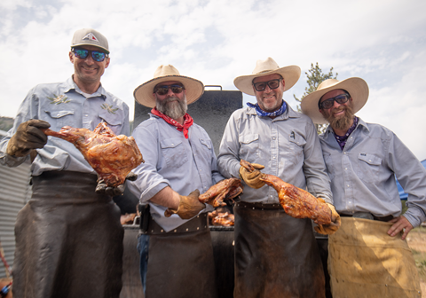Four men at the annual Asado cooking meat