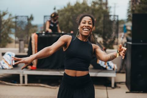 Woman smiling and dancing at the Wild Lotus Yoga Festival