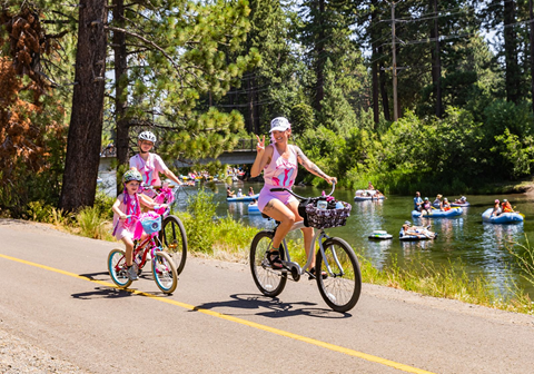Three bikers wearing pink by the Truckee River for Skate the Lake