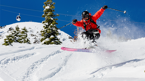 Skier flying through the air on a powder day at Palisades Tahoe