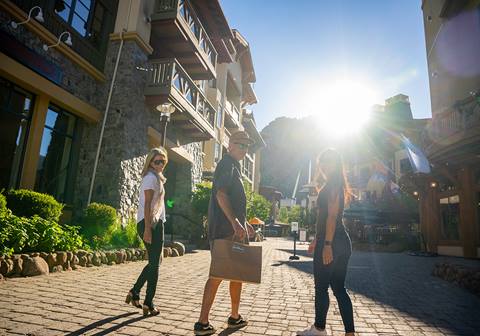 Three people walking in The Village at Palisades Tahoe