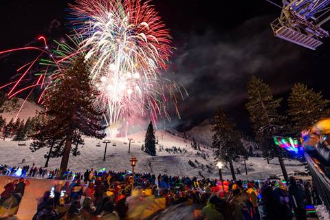 Fireworks lighting the sky above the Village at Palisades Tahoe on New Years Eve.