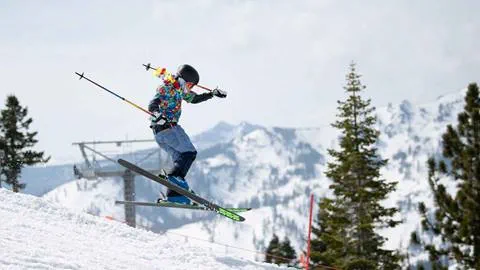 A skier in a Hawaiian shirt in the terrain park on a spring day at Palisades.
