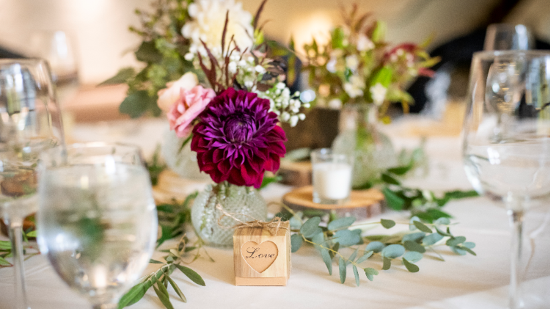 A flower arrangement on a table setting for a wedding.