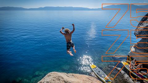 Young person jumping off of a rock into the clear blue waters of Lake Tahoe
