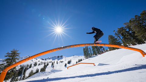 Snowboarder hitting a rainbow feature in the park