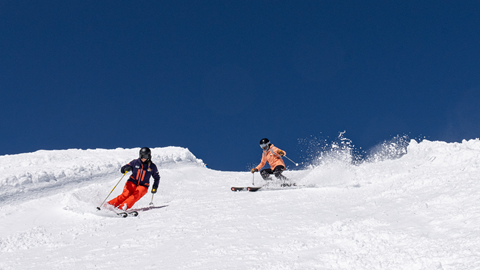 Instructor and skier skiing down the mountain