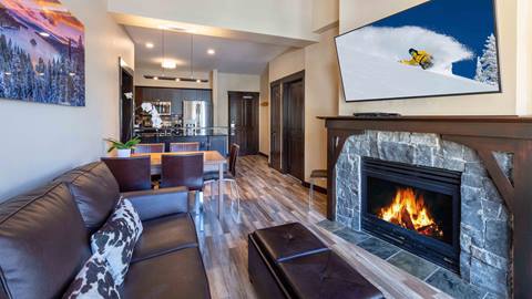 A two bedroom suite in The Village at Palisades Tahoe showing a fireplace, a living room, and a kitchen. 