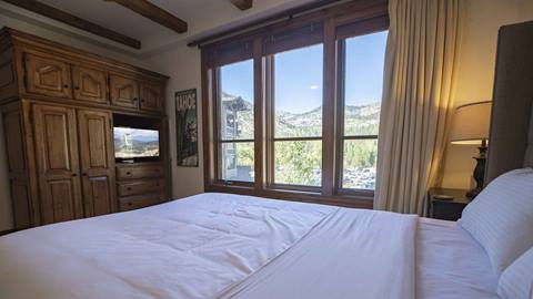 A bedroom in the Eagles Nest suite overlooking the mountains at Palisades Tahoe.