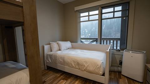 Guest bedroom of the Granite Peak Terrace room with small bed by the window.