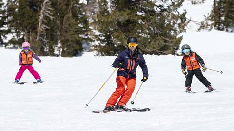 Two kids taking a private lesson from the Palisades Tahoe Mountain Sports School. 