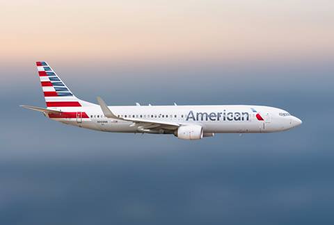 American Airlines plane flies through sky.