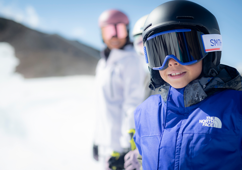 Close up photo of mom and son smiling in ski gear