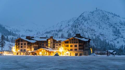 The Front Desk in The Village at Palisades Tahoe on a snowy night under the Tram Face.