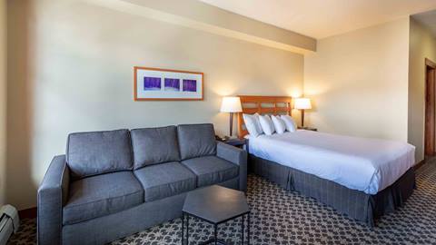 A Standard Room showing a couch and bedroom in The Village at Palisades Tahoe.