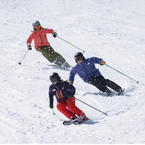 Two skiers with a Mountain Sports School instructor