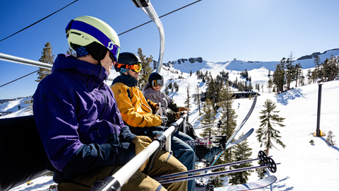 Friends riding the chairlift at Palisades Tahoe