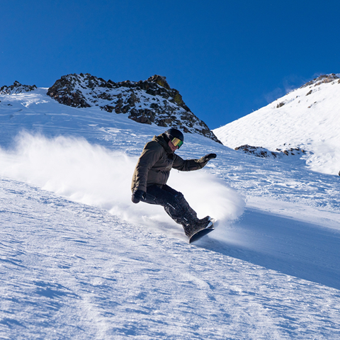 Snowboarder carving down the mountain