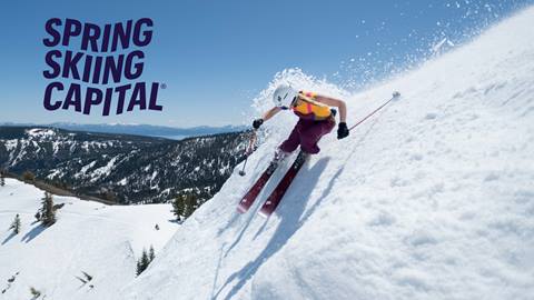 Amie Engerbretson skiing in a tank top with a view of Lake Tahoe in the background.