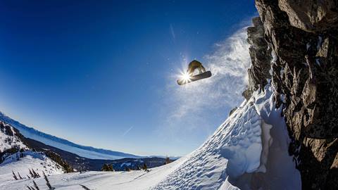 A snowboarder leaps in front of a sunspot at Alpine. 