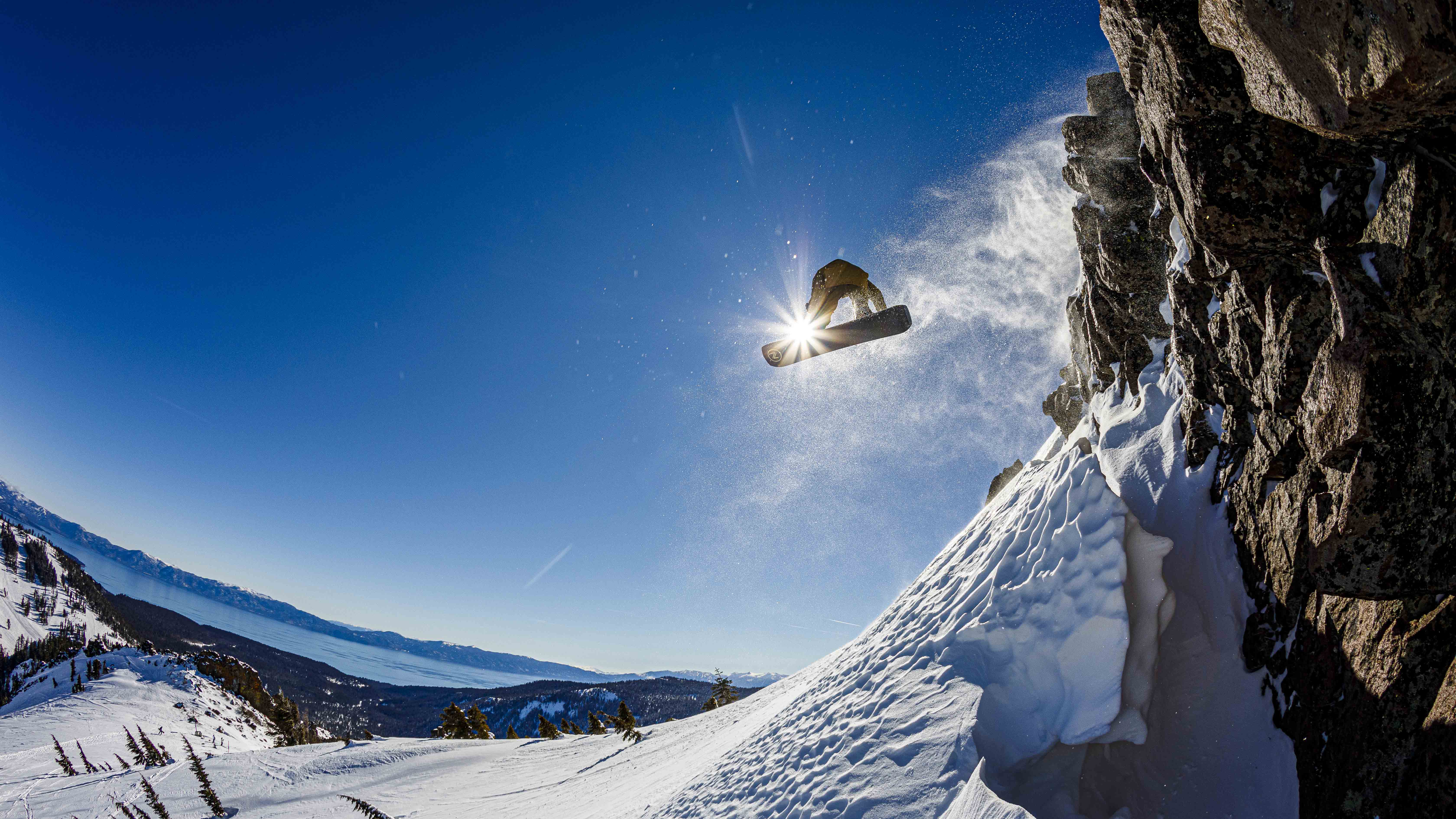A snowboarder leaps in front of a sunspot at Alpine.