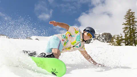 Snowboarder carving in slushy Spring snow.