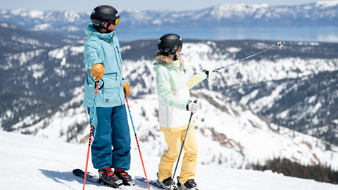 Two skiers overlook Lake Tahoe during Spring.