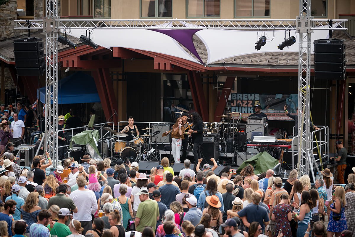 A singer on stage at the Blues Jazz and Funk festival, surrounded by a large crowd of people.