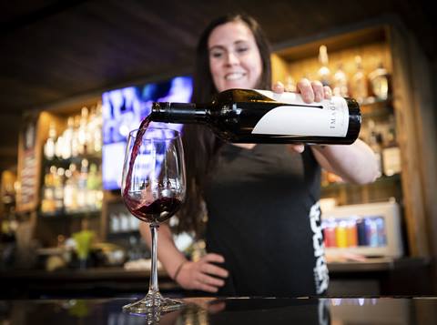 Bartender pouring wine glass