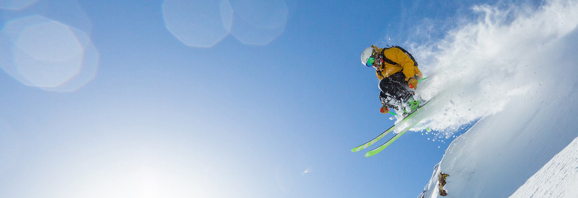 Skier launching off a cliff on a bluebird powder day at Alpine Meadows, California