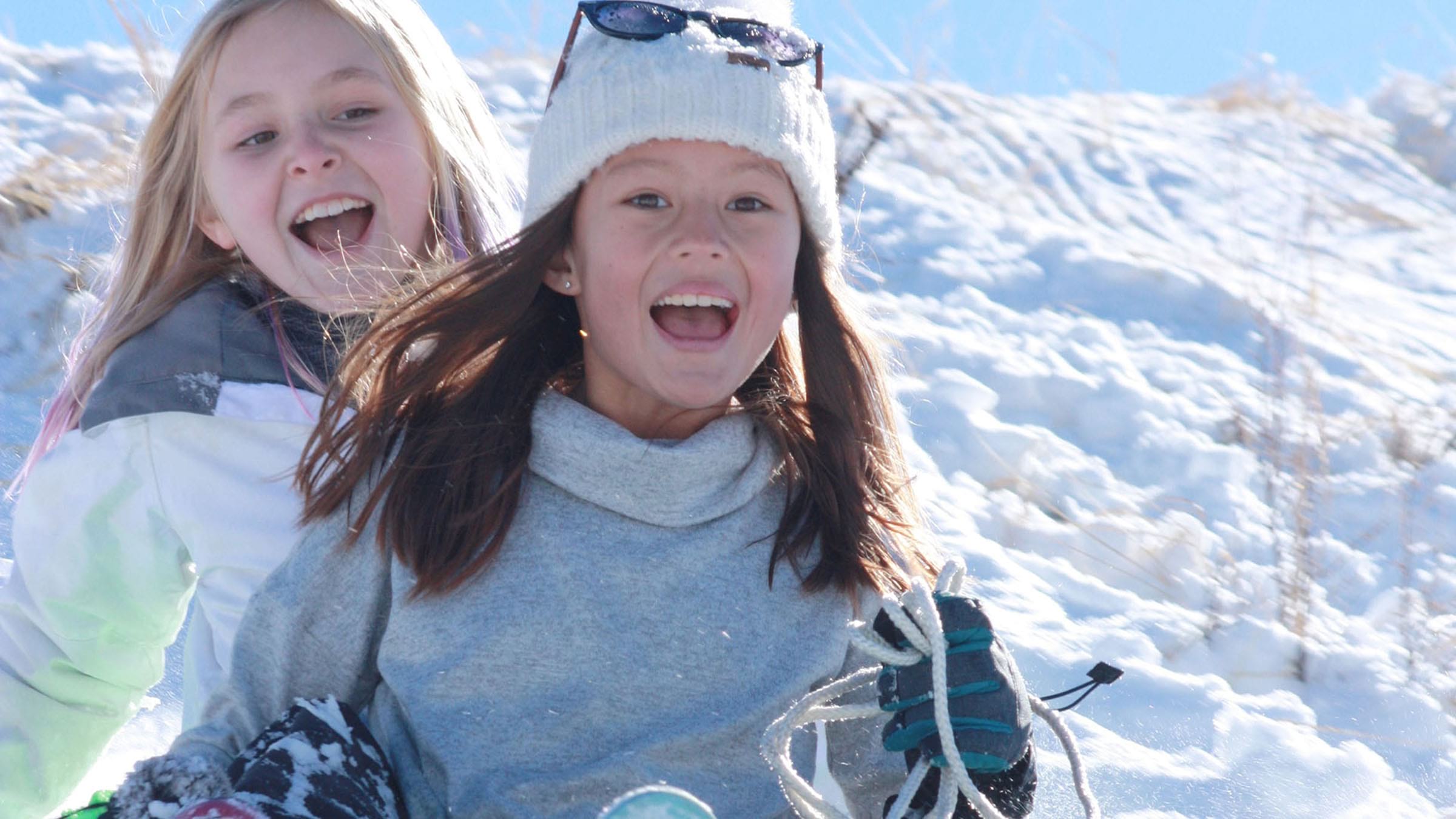 Two girls enjoy sledding in Lake Tahoe.