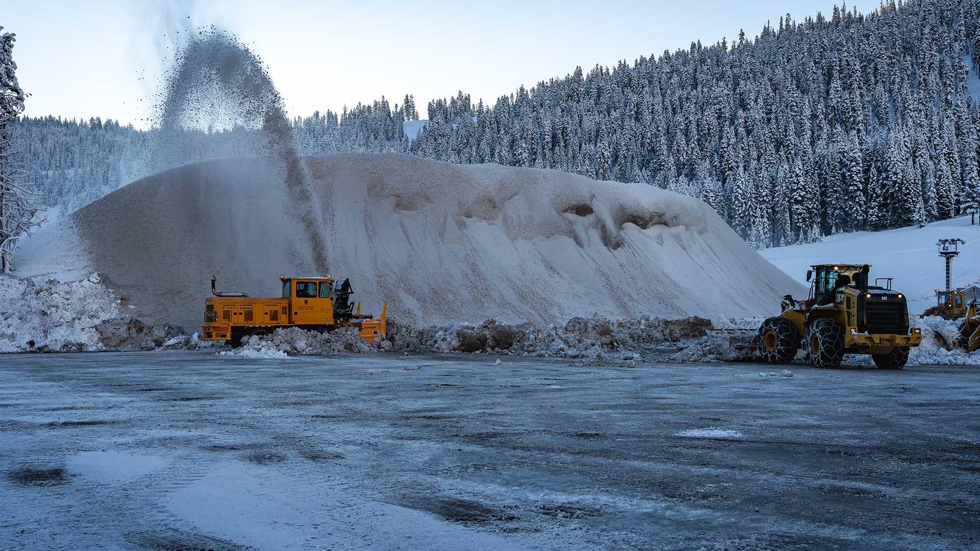 Machines work to remove snow in the Palisades parking lot. 