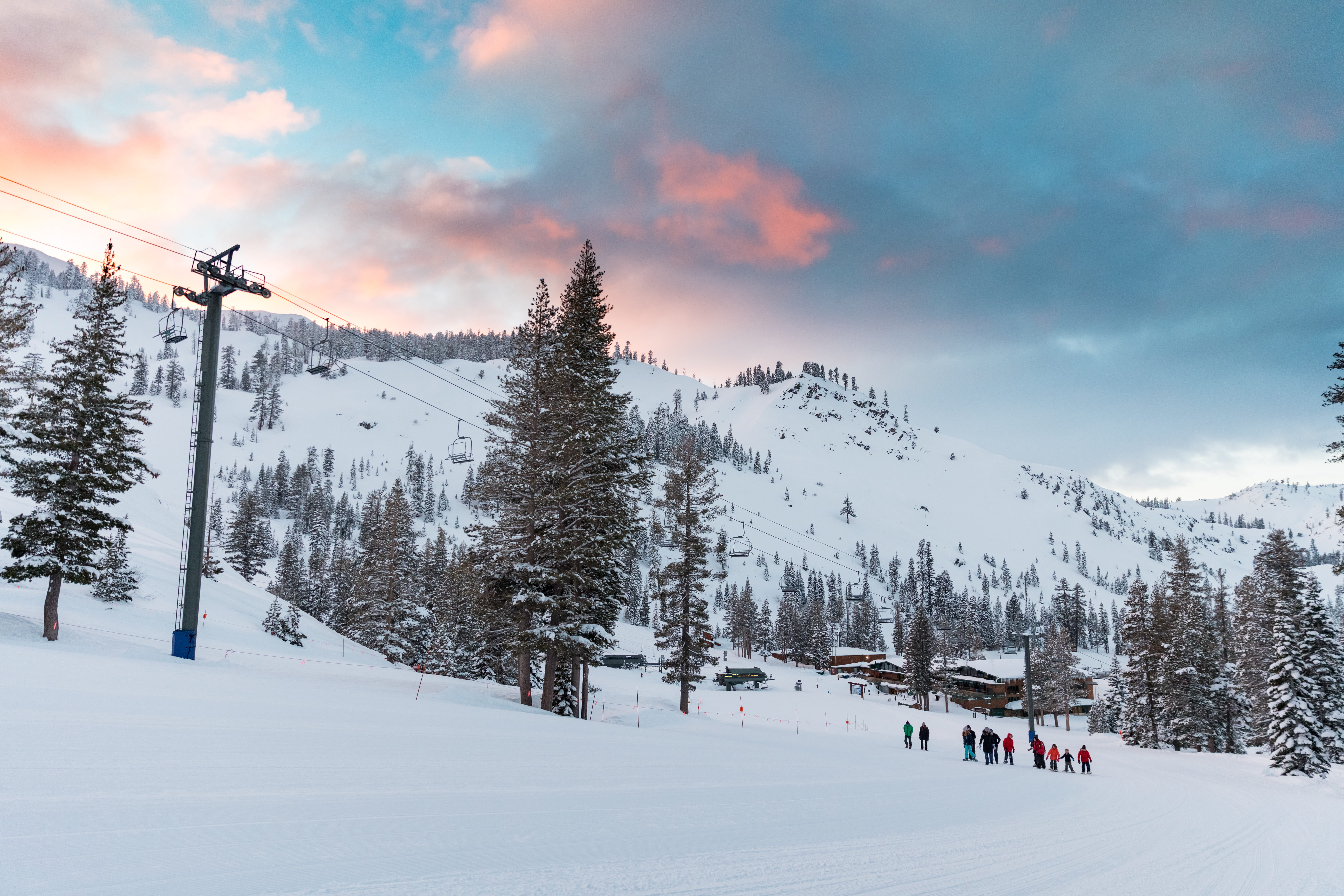A group of people snowshoeing at Alpine Meadows at sunset. 