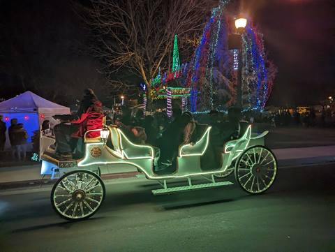An e-carriage lit up at night for the holidays.