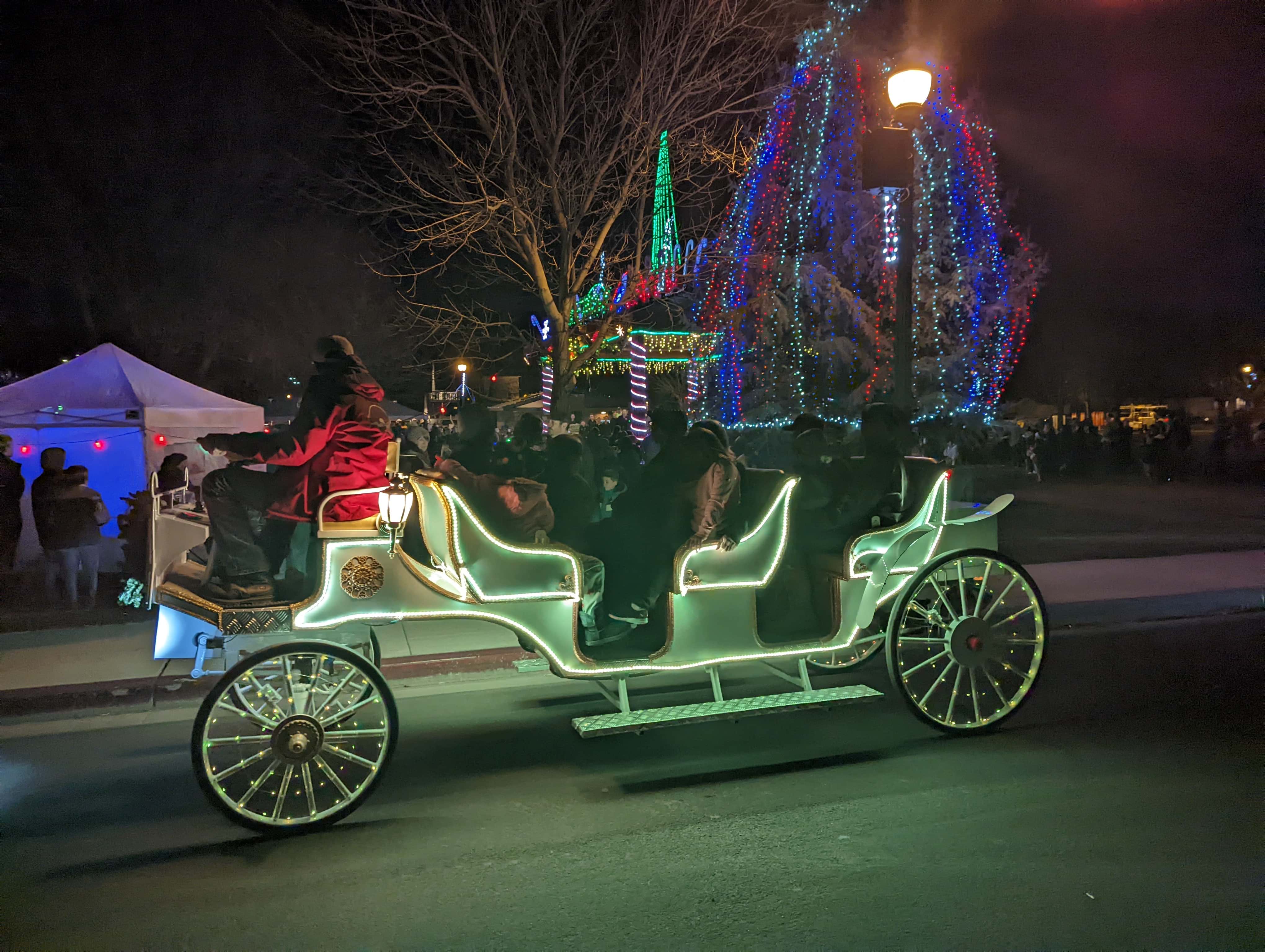 An e-carriage lit up at night for the holidays.