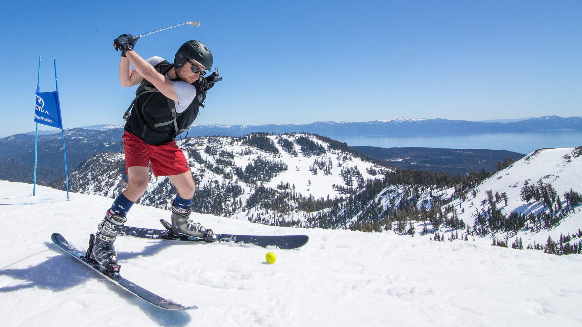 Skier participating in the Alpine Snow Golf Tournament with Lake Tahoe in the background