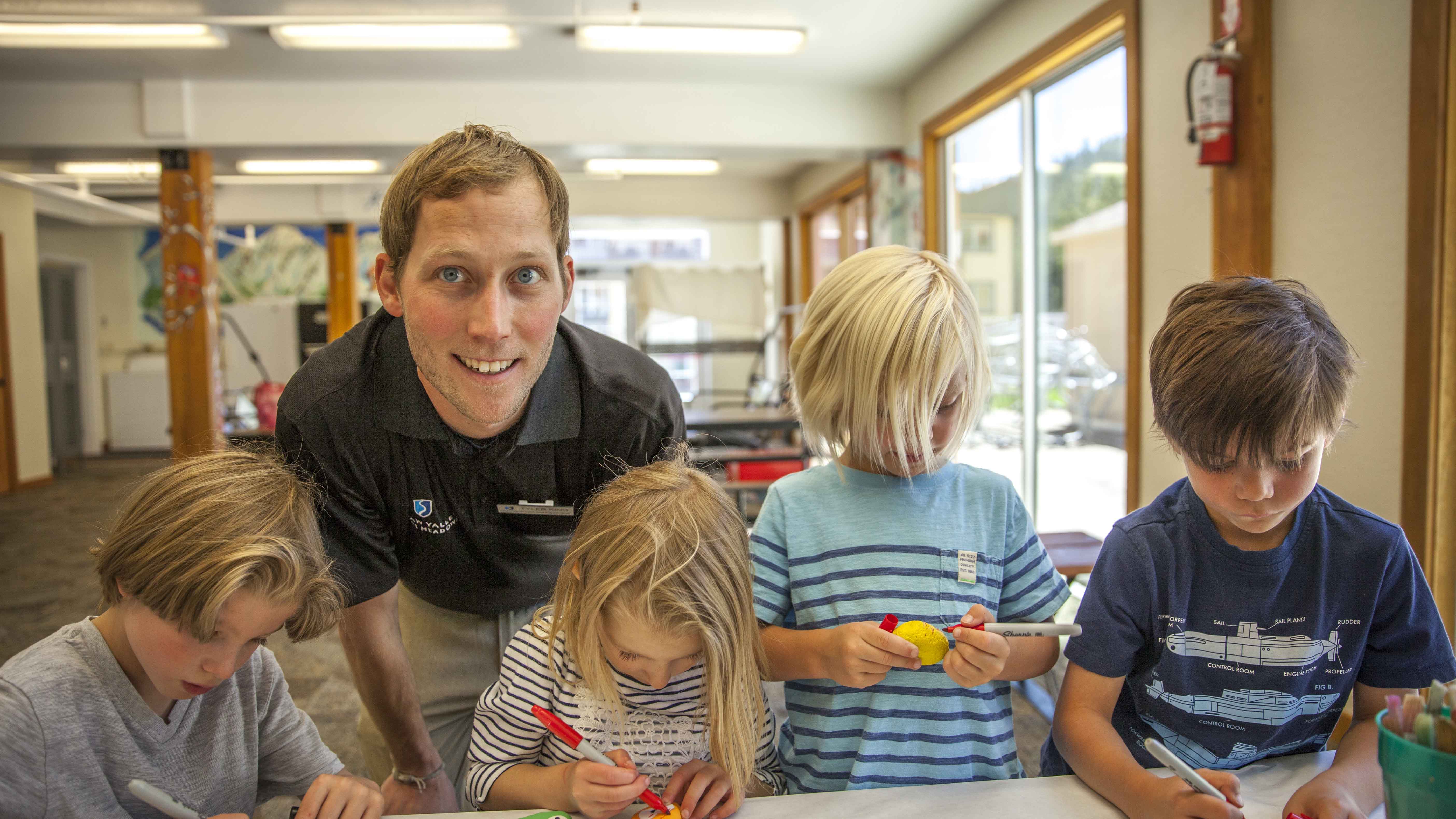 Head counselor Tyler King does arts & crafts with campers. 