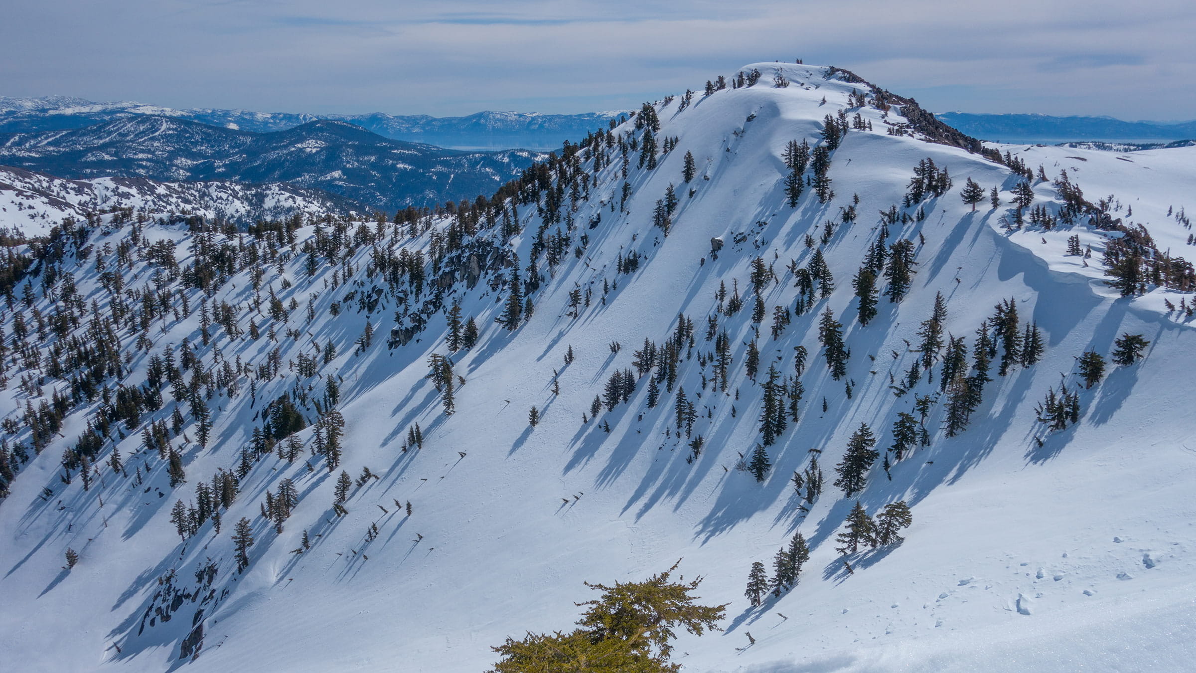 Nat Geo Bowl adjacent to Palisades Tahoe can be accessed through backcountry tours with Alpenglow Expeditions